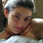 maman solo tenant son bébé dans les bras à la maison