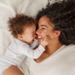 Femme célibataire seule avec son bébé dans un lit illustrant le choix d'avoir un enfant célibataire