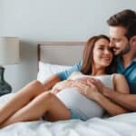 un homme et une femme dans un lit qui s'accouple avec une insémination naturelle pour avoir un enfant