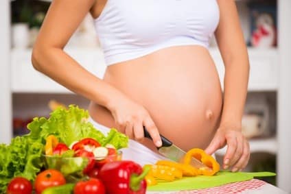 aliments pour tomber enceinte femme enceinte cuisinant des aliments sains en cuisine