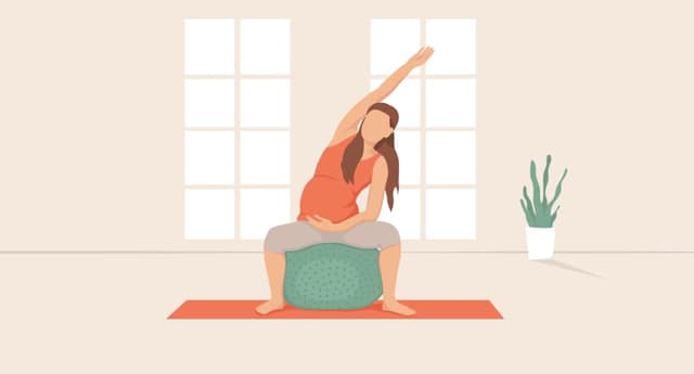 Jeune femme enceinte faisant des exercices de yoga sur une balle de fitness.