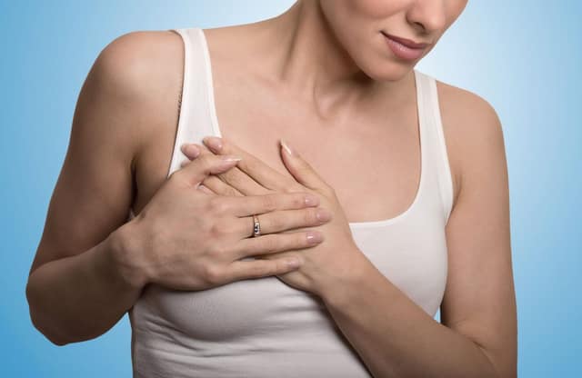 grossesse après cancer illustrée par une femme touchant sa poitrine