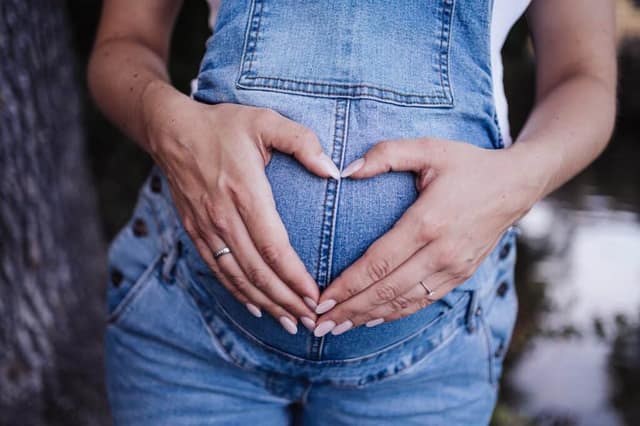 Grossesse, Femme enceinte avec ses mains sur le ventre