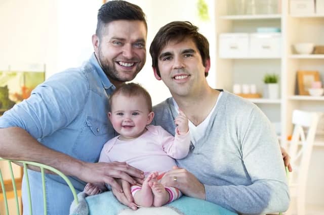 Couple de pères avec leur bébé illustrant l’homoparentalité
