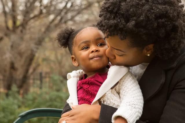 Mère qui embrasse sa fille moment de tendresse lien affectif parent enfant amour familial