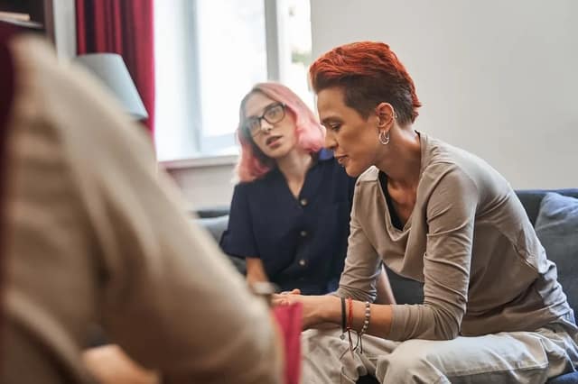 Couple LGBT en consultation discutant d'un refus de PMA avec un professionnel de santé