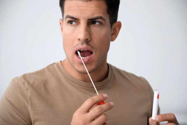 test de paternité homme réalisant un test ADN avec prélèvement biologique