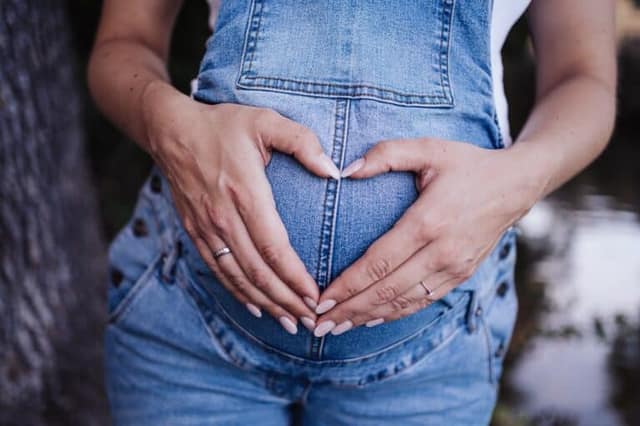 Grossesse, Femme enceinte avec ses mains sur le ventre
