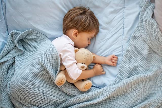 Photo de bébé dormant avec l'ours de nounours