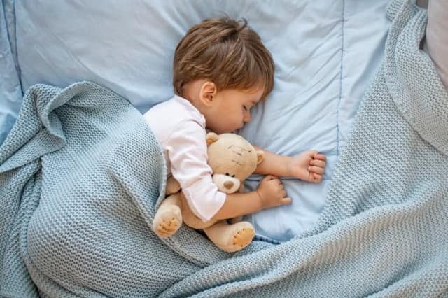 Photo de bébé dormant avec l'ours de nounours