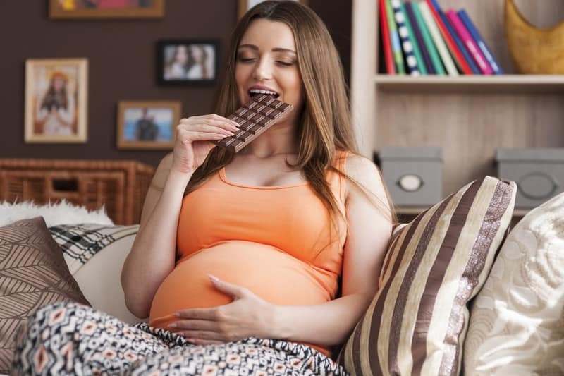 Femme enceinte qui mange du chocolat