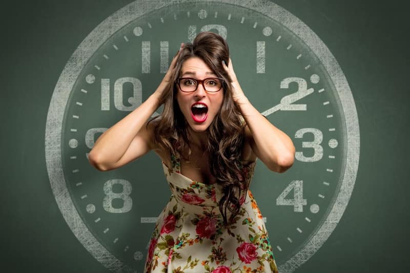 femme qui panique avec une horloge dans le fond illustrant l'horloge biologique