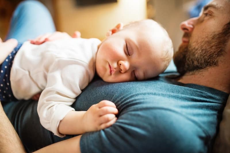 papa qui dort avec son bébé sur le ventre