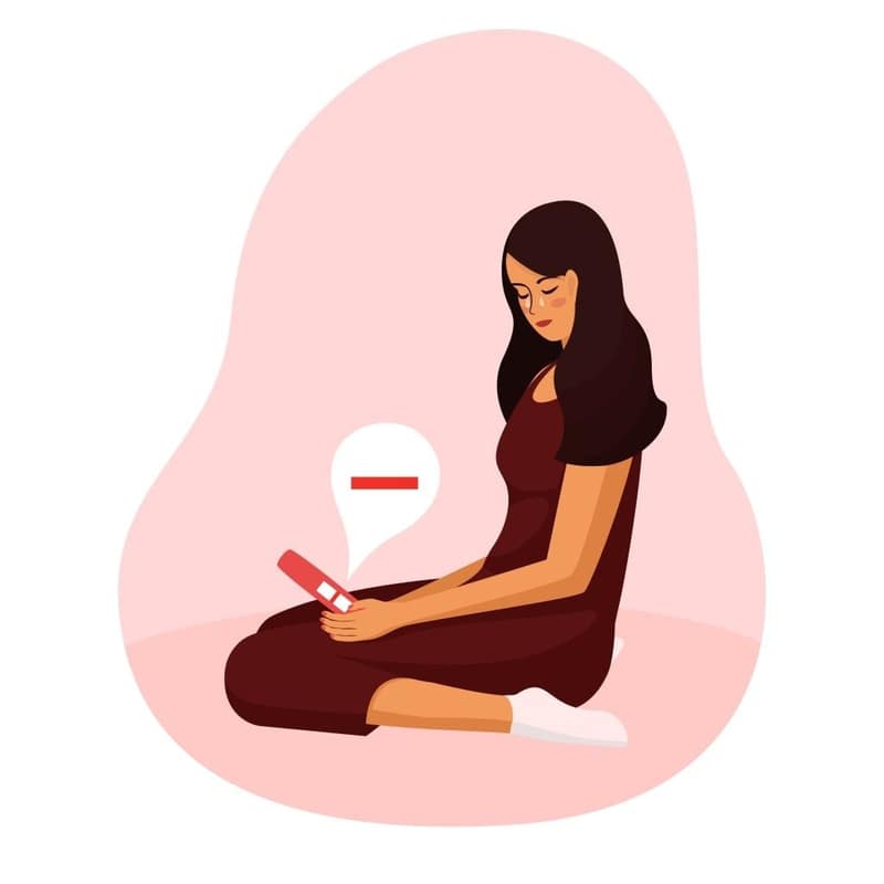 Femme qui regarde un test de grossesse négatif