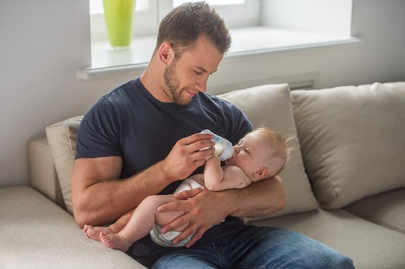 Père célibataire tenant son bébé dans les bras à la maison
