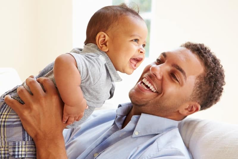 Différence entre géniteur et père illustrée par un homme tenant son bébé