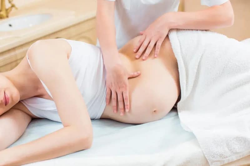 Femme enceinte se faisant masser le ventre
