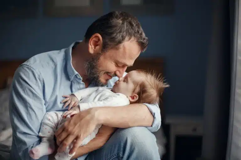 Devenir papa avec père embrassant son bébé dans un moment tendre et affectueux