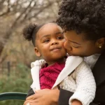 Mère qui embrasse sa fille moment de tendresse lien affectif parent enfant amour familial