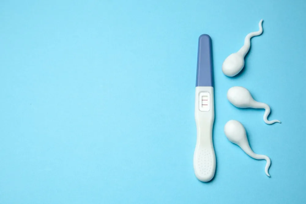 Enceinte par don de sperme test de grossesse positif avec représentation de spermatozoïdes sur fond bleu